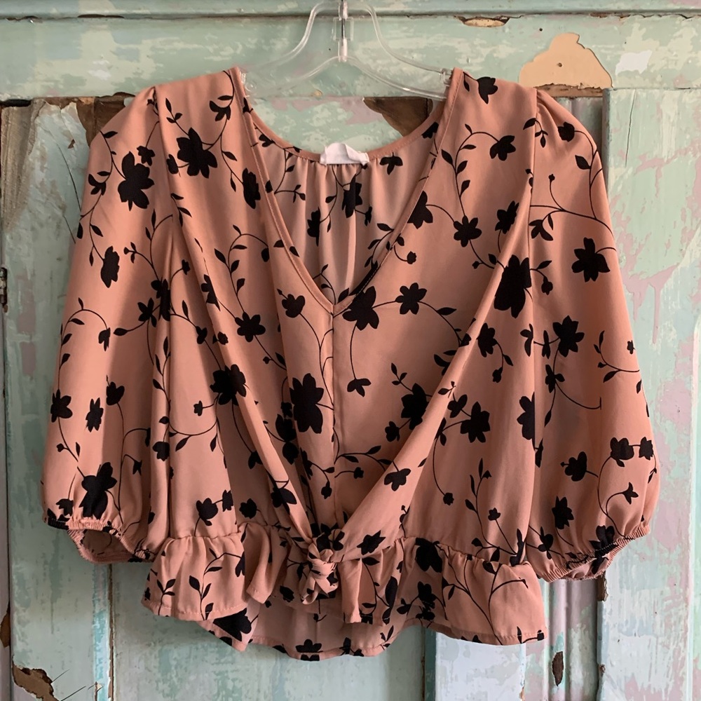 Pink cropped blouse with black flowers on it
